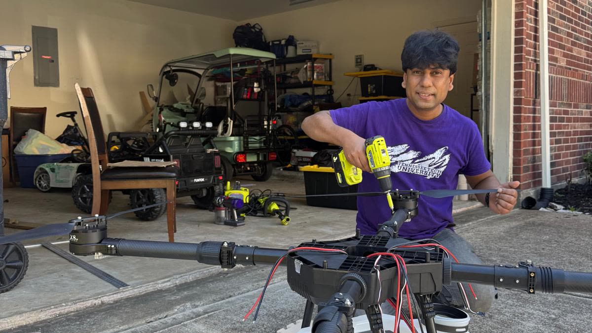 A KaiLAB engineer fitting a propeller arm to a spray UAV with a power driver